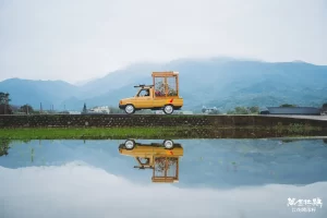 flower truck driving through Wan Jin Azalea Festival 2024 fields with mountain reflection, symbolizing freedom and blooming happiness